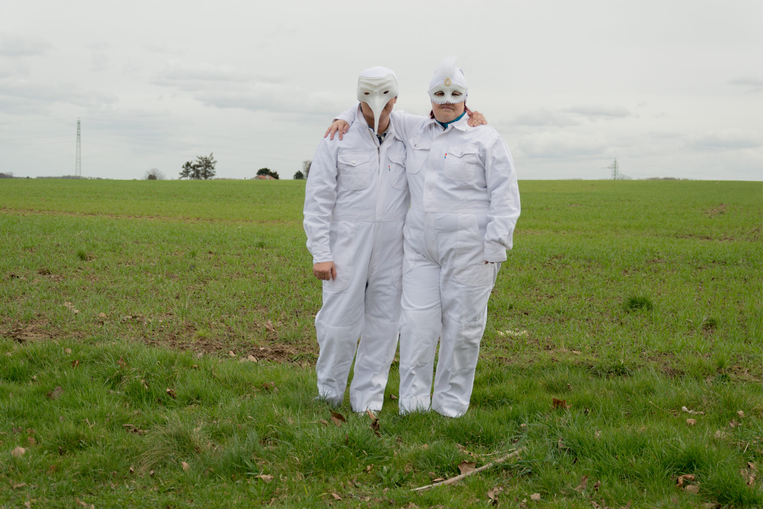 Deux personnes handicapées dans un champs en habits blancs et masques blancs
